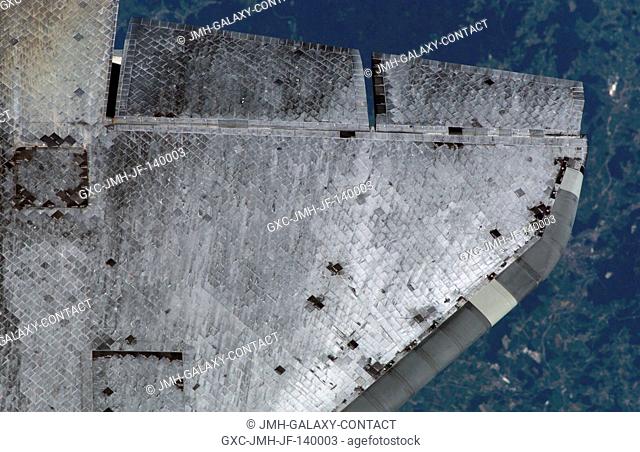 View of the Space Shuttle Discovery's underside starboard wing and Thermal Protection System tiles photographed during the survey sequence performed by the...