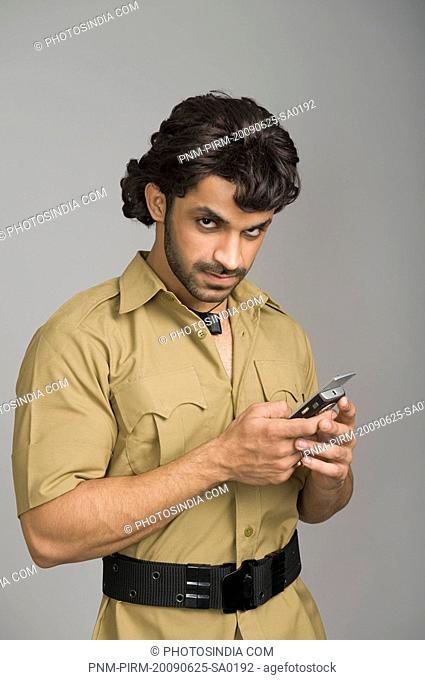 Portrait of an actor portraying Gabbar Singh using a mobile phone