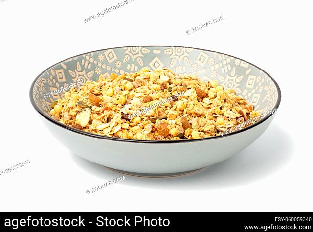 oatmeal crunches with raisins, pumpkin seeds and sunflower seeds in a gray round ceramic plate on white background