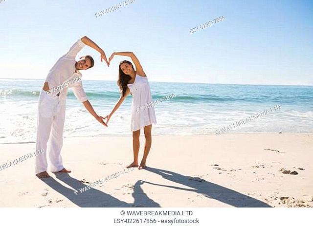 Loving couple forming heart shape with arms