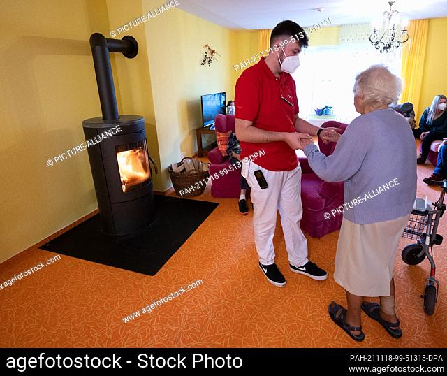 18 November 2021, Baden-Wuerttemberg, Burladingen: A caregiver helps a resident in a residential group at the BeneVit Group's Haus Fehlatal retirement home