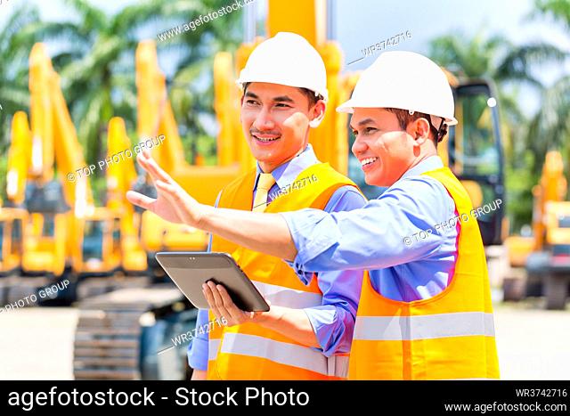 Asian engineer controlling construction machinery of construction site or mining company