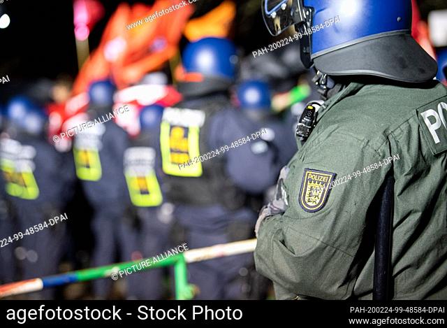 24 February 2020, Baden-Wuerttemberg, Pforzheim: Policemen with the small state coat of arms of Baden-Wuerttemberg stand at a demonstration against a right-wing...