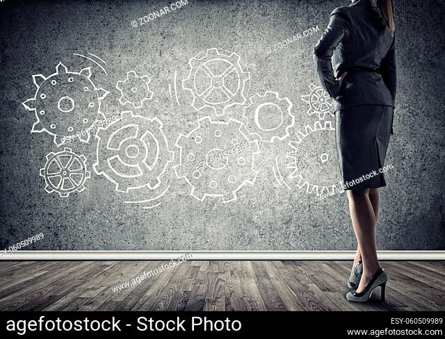 Bottom view of businesswoman and teamwork drawn concept on wall