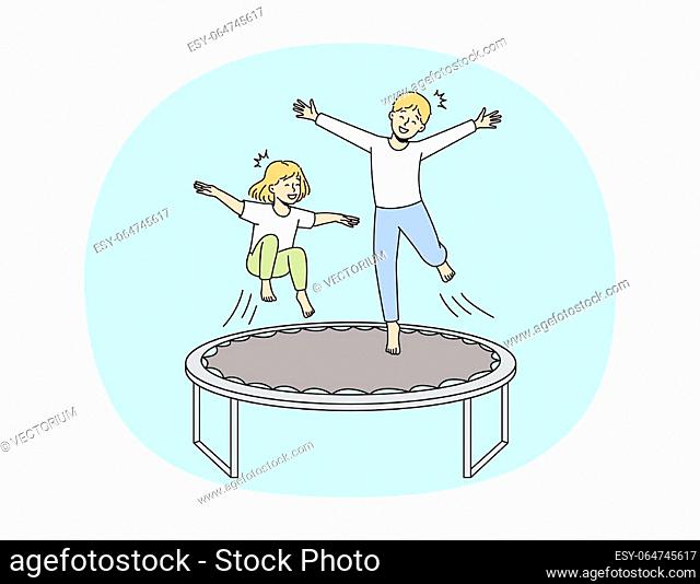Overjoyed small kids have fun jumping on trampoline outdoors. Smiling little children enjoy playing outside involved in funny playful game