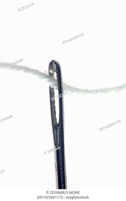 Needle with thread on white background