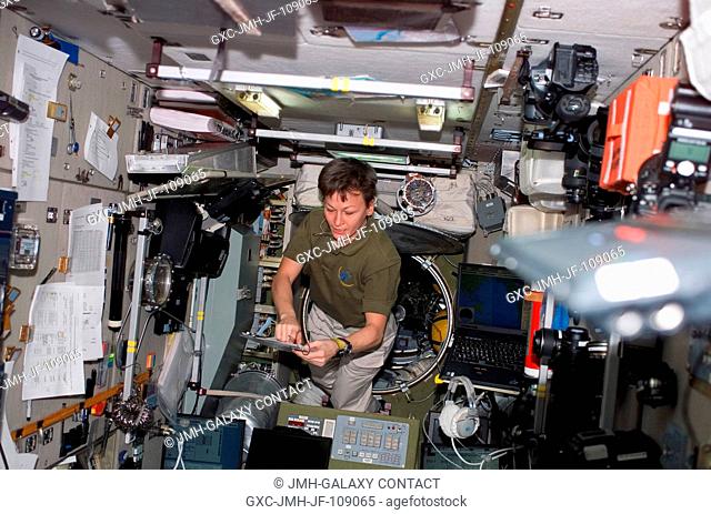 Astronaut Peggy Whitson, Expedition 16 commander, looks over a checklist in the Zvezda Service Module of the International Space Station while Space Shuttle...