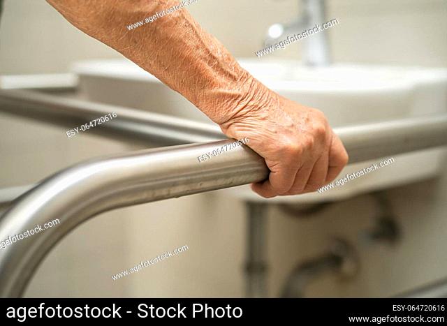 Asian elderly woman patient use toilet bathroom handle security in nursing hospital, healthy strong medical concept