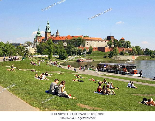 Poland, Krakow, people resting by Vistula river, Wawel Hill