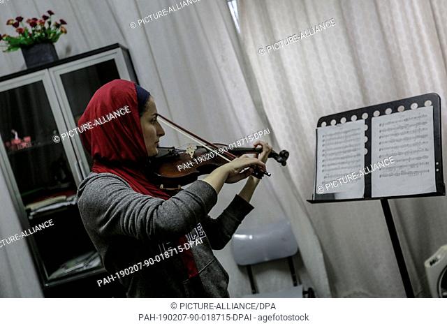 06 February 2019, Palestinian Territories, Gaza City: A Palestinian student plays violin during a music class at the Edward Said National Conservatory of Music