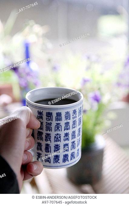 Close-up of hand holding asian style coffee cup