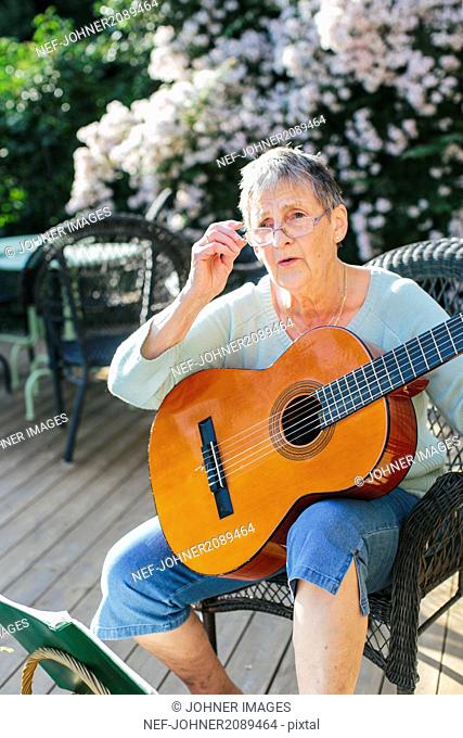 Senior woman playing guitar
