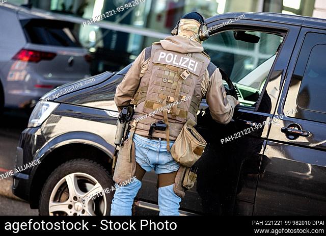 21 December 2022, Baden-Wuerttemberg, Schorndorf: A police officer stands by an emergency vehicle and talks to a colleague