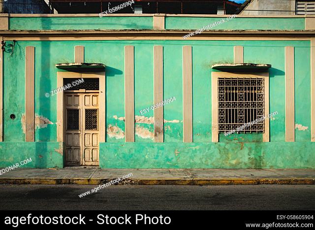 Facade of typical Mexican green abandoned colonial building in Merida, Yucatan, Mexico