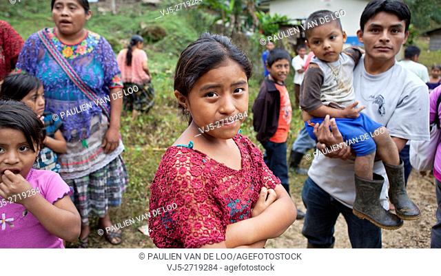 Chahal, Guatemala, a maya tribe in the jngle of Guatemala. A curious father is watching his daughter and carrying his son