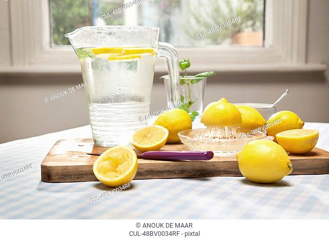 Lemons, juicer and pitcher of water
