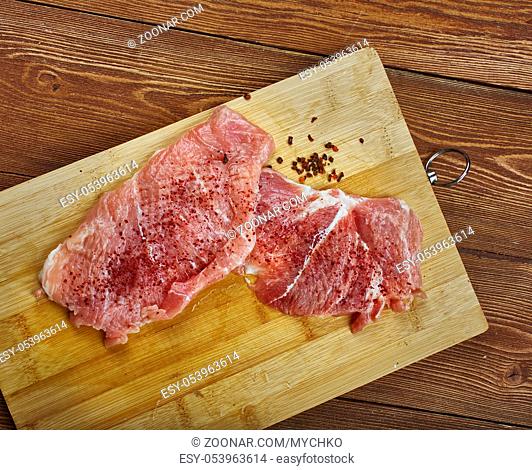 Raw cut meat on a wooden board. Pork chunks for chops , cooking pork chop
