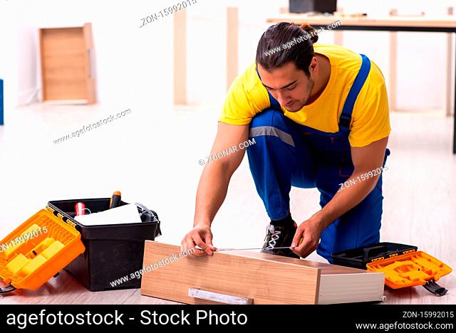 Young male carpenter working indoors at home