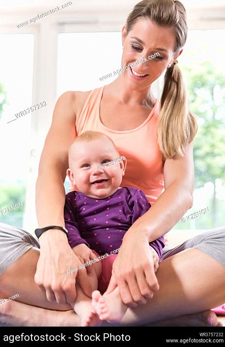 Mum and her baby child in pregnancy recovery course playing