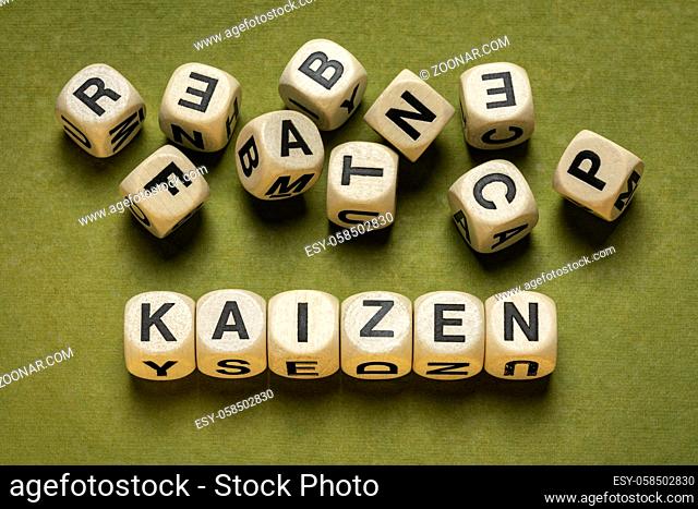 kaizen word abstract in wooden letter cubes against green handmade paper in green tones, Japanese continuous improvement and a change for better concept