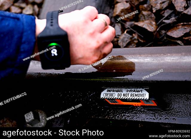 A worker demonstrates a wrist watch showing a notification a train is arriving, and the Infralert device at the presentation of two new safety systems of...