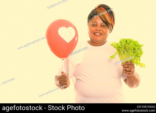 Studio shot of beautiful overweight African woman ready for gym isolated against white background