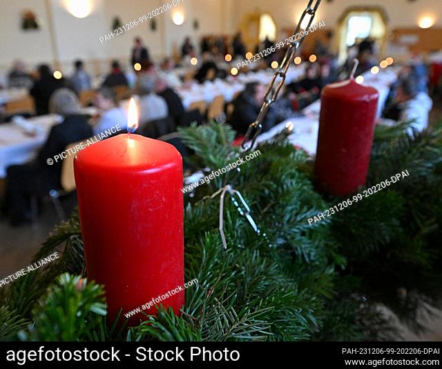06 December 2023, Thuringia, Erfurt: A candle lights up on the Advent wreath in the Restaurant des Herzens of the Evangelical City Mission. From St