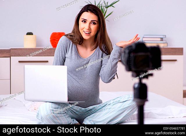 The pregnant woman recording video for her blog