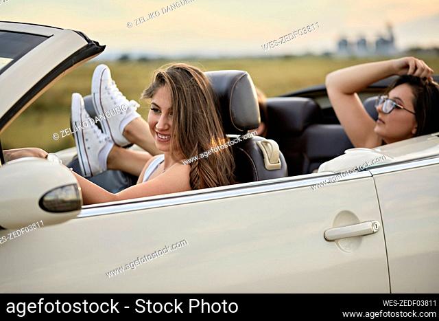 Friends Traveling for road trip in luxury car during sunset