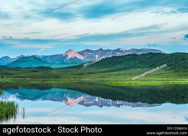 Evening clouds breaking over Healy Lake in the Alaska Range in South-central Alaska on a cloudy summer evening; Alaska, United States of America