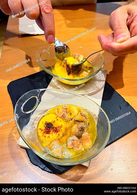 Hands mixing ingredients in a tapa made of foie, egg and olive oil. Bar Pasion, Laurel street, Logroño, la Rioja, Spain