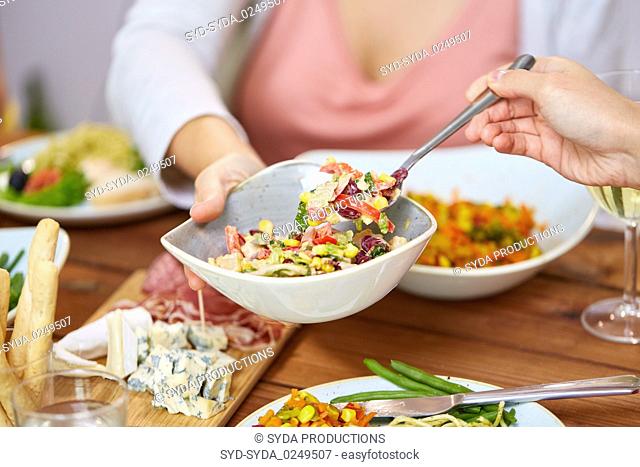 people eating salad at table with food