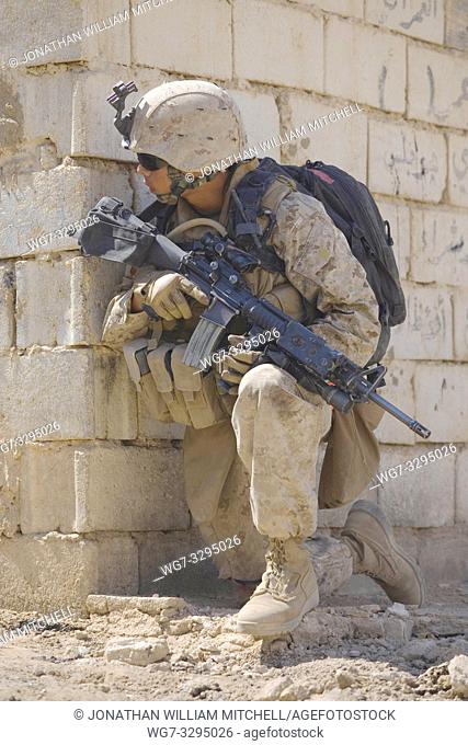 IRAQ Hit -- 11 Sep 2007 -- US Marine Corps Pfc Orlando R Sudduth looks around a corner during a patrol halt in Hit, Iraq