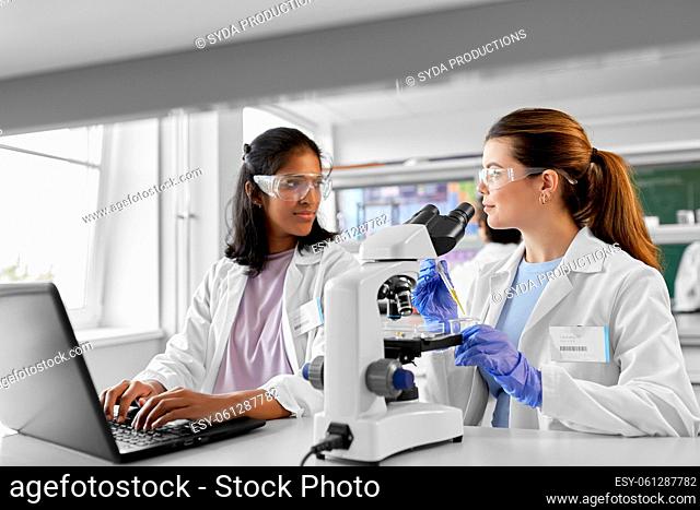 scientists with microscopes working in laboratory