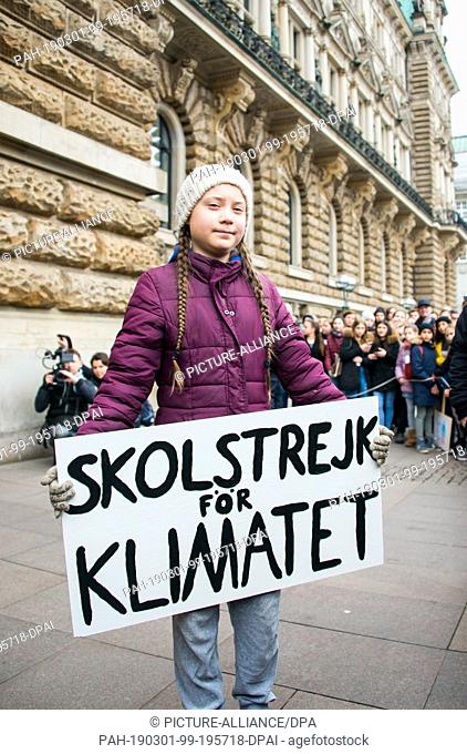 01 March 2019, Hamburg: Greta Thunberg, climate activist, stands with a banner in front of a rally on the town hall market in front of the town hall