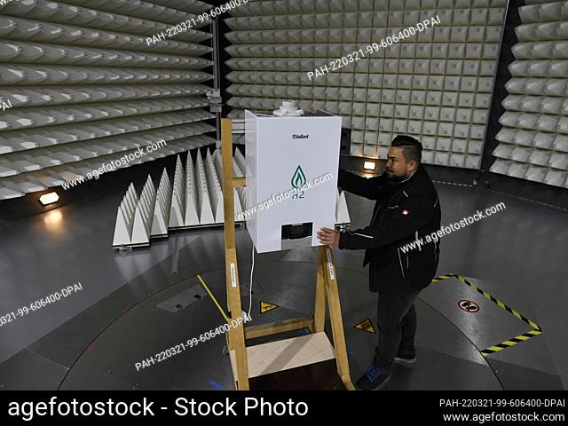 18 March 2022, North Rhine-Westphalia, Remscheid: A Vaillant employee installs a heat pump for a test in the EMC chamber at the company's headquarters