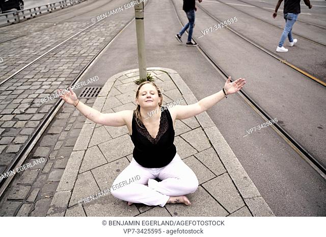 Woman sitting on the street, Munich, Germany