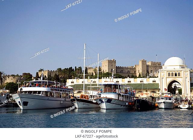 Ships and boats anchoring in Mandraki harbour translated literally: fold, Palace of the Grand Master and Nea Agora in background, Rhodes Town, Rhodes, Greece