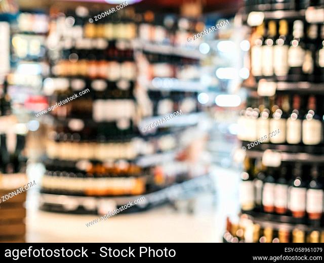 Abstract blurred supermarket colorful shelves with alcohol, wine bottles as background