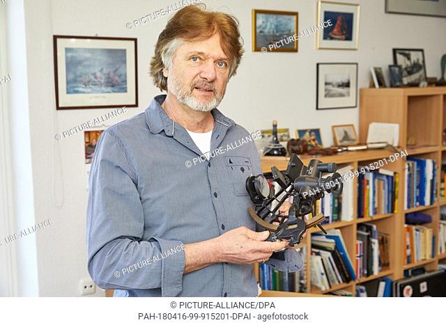 16 April 2018, Germany, Bad Bramstedt: Explorer Arved Fuchs stands in his study holding sextant in his hand. Fuchs will turn 65 on 26 April 2018