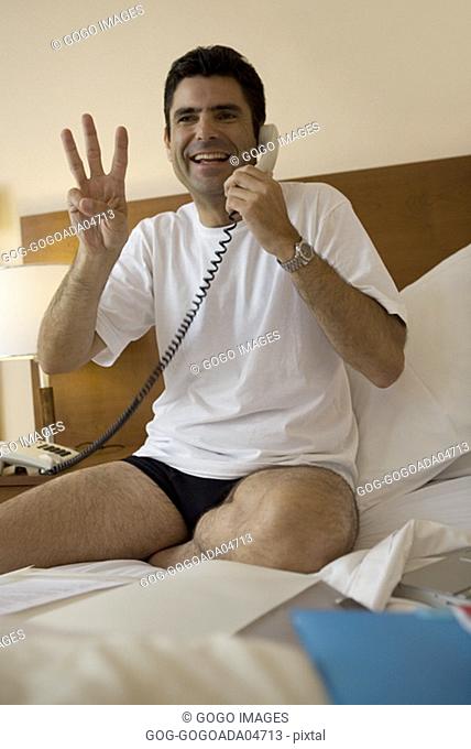 Man talking on phone in hotel room