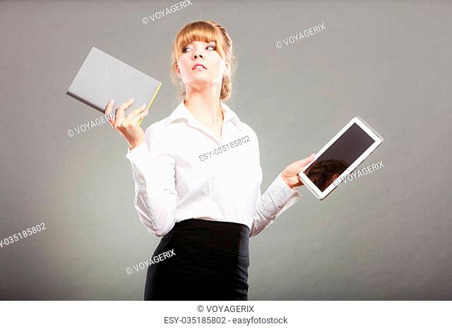 Woman holding ebook reader and book. Choice between modern educational technology and traditional way method. Girl with digital tablet pc and textbook