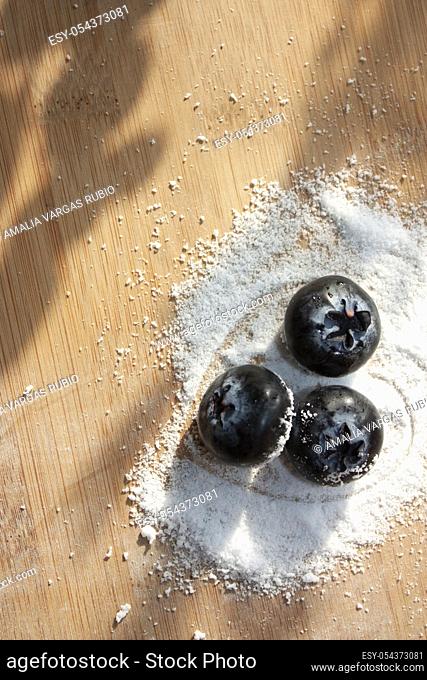 Heart armed by sugar-free sweetener granules blueberry trio container on a wooden board to make desserts with heart
