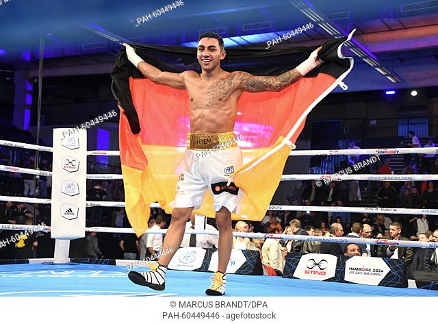 Artem Harutyunyan of Germany holds the German national flag in his hands and cheers after winning the qualification bout for the 2016 Rio Olympic Games against...