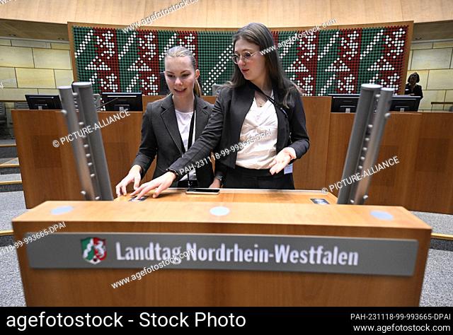 18 November 2023, North Rhine-Westphalia, Duesseldorf: Two young women look at the lectern before the start of this year's plenary session of the North...