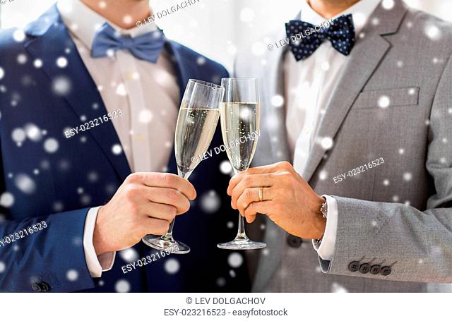 people, celebration, homosexuality, same-sex marriage and love concept - close up of happy married male gay couple in suits drinking sparkling wine and clinking...