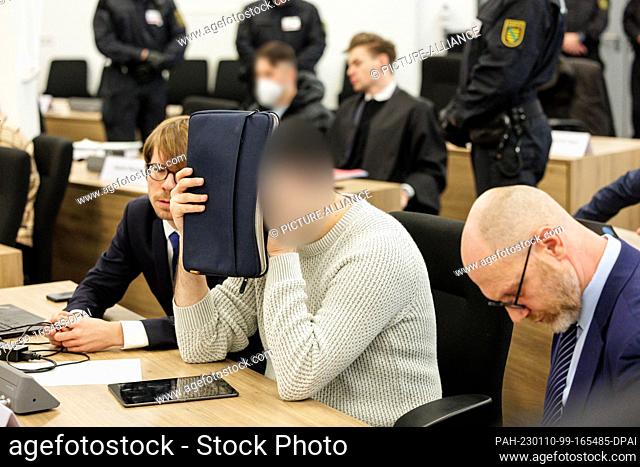 10 January 2023, Saxony, Dresden: A defendant (M) covers his face in the courtroom of the Dresden Higher Regional Court before the trial on the jewel heist in...