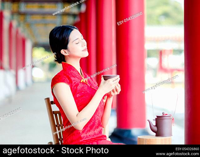 beautiful Asian woman in old traditional Chinese dresses drinking tea in the Temple