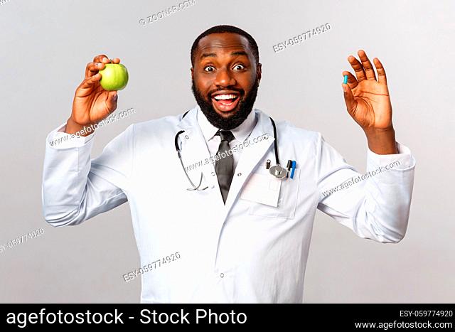 Healthcare, medicine and healthy lifestyle concept. Enthusiastic african-american doctor advice stay healthy with eating more vitamins, fruits