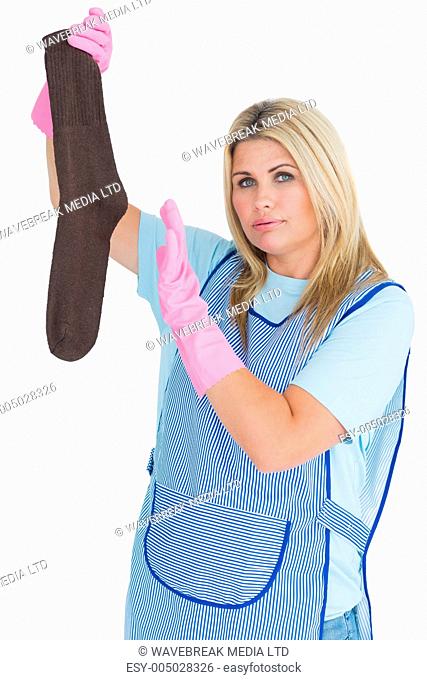 Cleaning woman holding a dirty sock in the white background